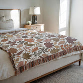 Cozy fall scene with cream fall woven blanket blanket on bed